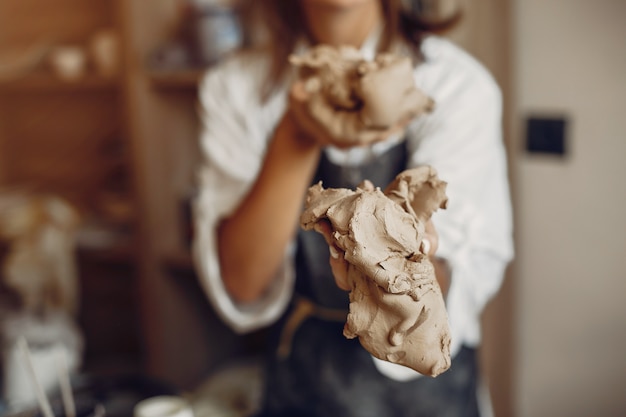 Photo gratuite jeune femme fait de la poterie en atelier