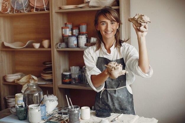 Jeune femme fait de la poterie en atelier