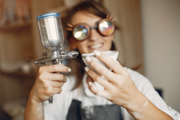 Jeune femme fait de la poterie en atelier