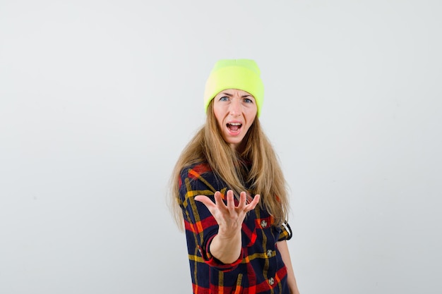 Jeune femme femme dans une chemise à carreaux avec un chapeau