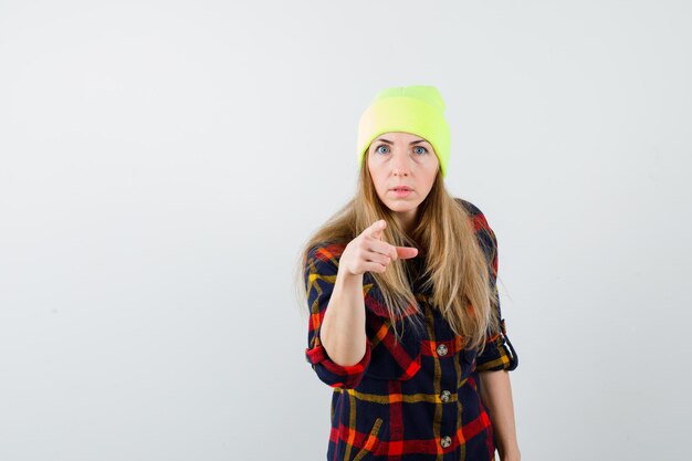 Jeune femme femme dans une chemise à carreaux avec un chapeau