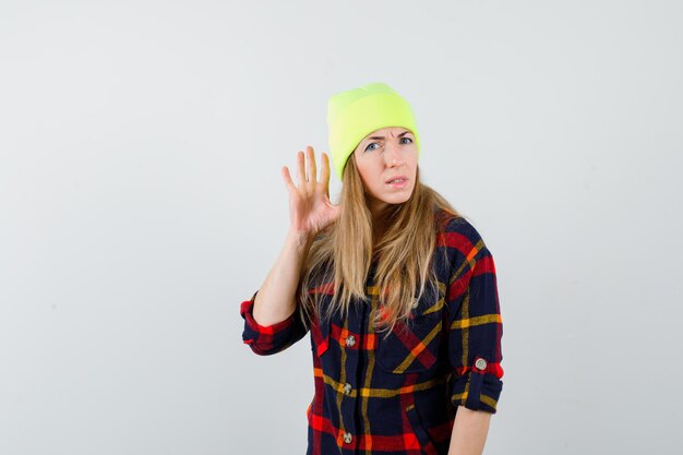 Jeune femme femme dans une chemise à carreaux avec un chapeau