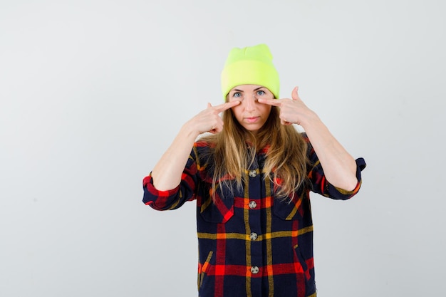 Jeune femme femme dans une chemise à carreaux avec un chapeau