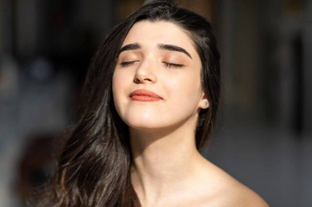 La jeune femme a fermé les yeux et le soleil brille sur sa photo de haute qualité