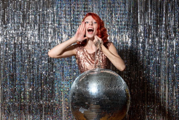 Photo gratuite jeune femme en fête avec boule disco sur des rideaux lumineux