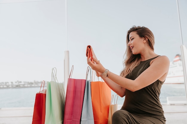 Photo gratuite jeune femme fière de son nouveau sac à main