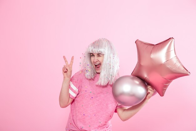 Jeune femme ou fille avec des ballons et montre deux doigts. Paix. Concept de vacances et de fête.