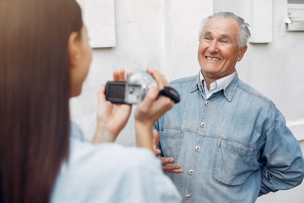 Photo gratuite jeune femme filmant son grand-père