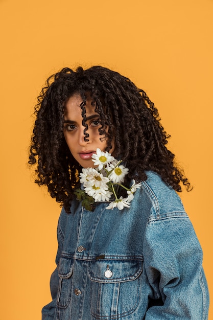 Jeune femme avec des fleurs au cou, regardant la caméra