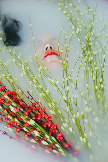 Photo gratuite jeune femme avec des fleurs dans l'eau