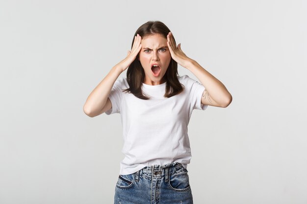 Jeune femme folle et frustrée à la caméra choquée