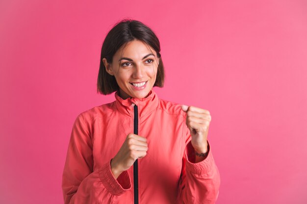 Une jeune femme en forme de veste de sport sur rose combat le geste de la boîte