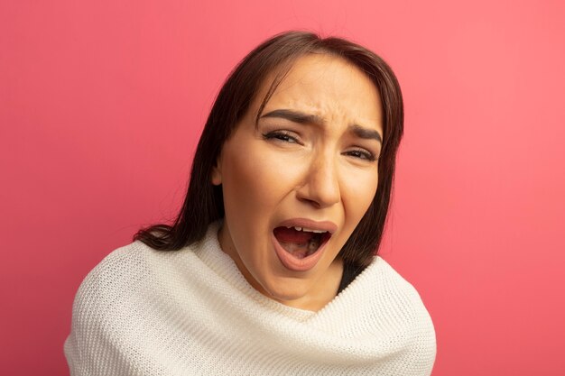 Jeune femme avec un foulard blanc criant et hurlant avec une expression agacée