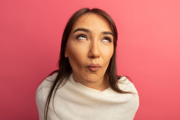 Jeune femme avec foulard blanc roulant les yeux d'être mécontent