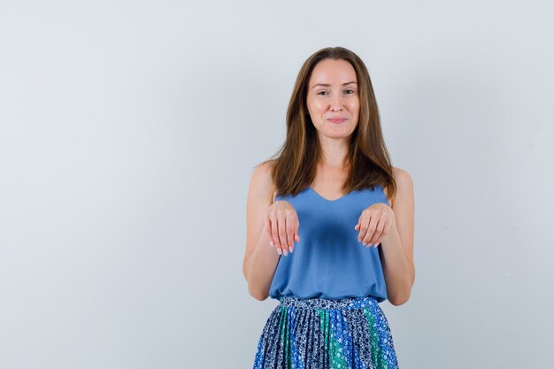 Jeune femme en gardant les mains comme des pattes en maillot, jupe et à amusé