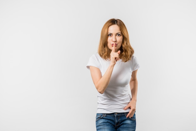 Jeune femme, geste silence, à, doigt, lèvres, blanc, fond