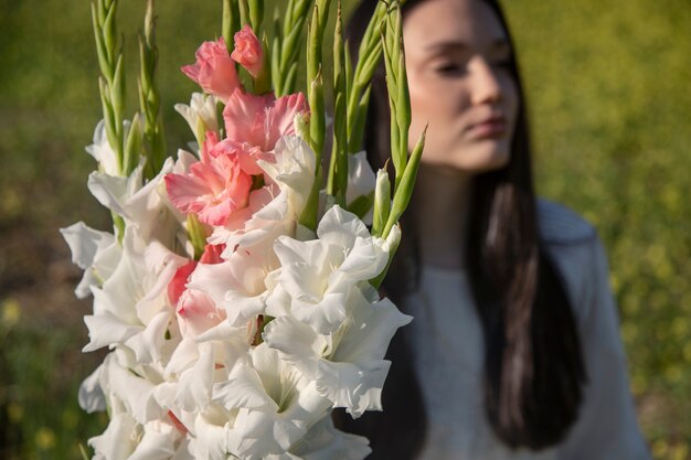 Jeune femme avec glaïeul dans la nature