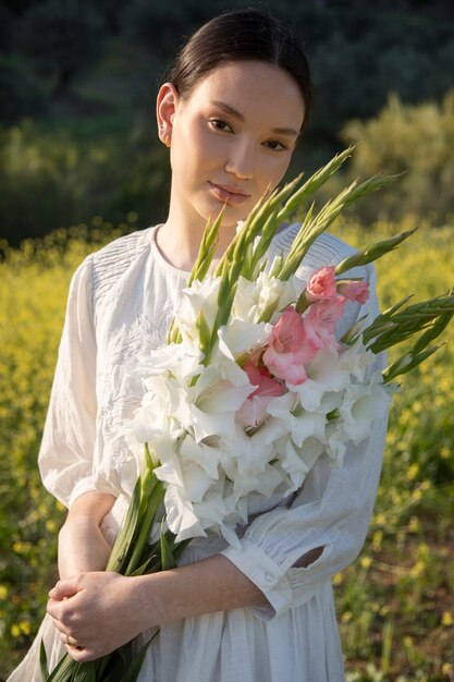 Jeune femme avec glaïeul dans la nature