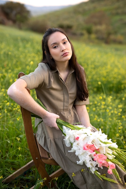 Jeune femme avec glaïeul dans la nature