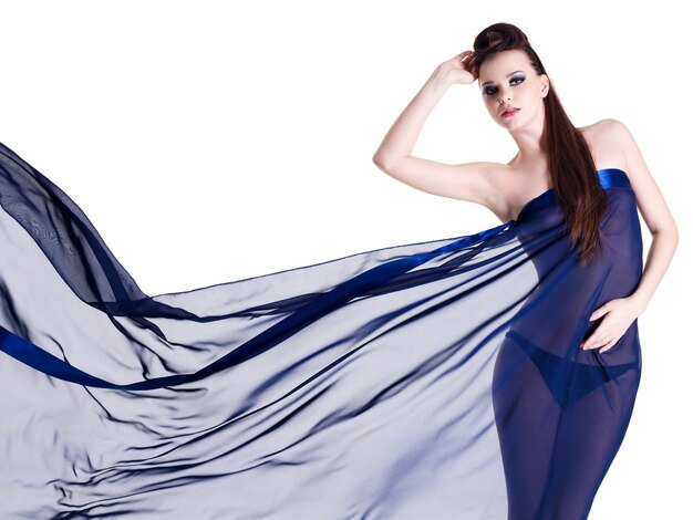 Jeune femme glamour sensualité en mousseline de soie bleu foncé sur blanc
