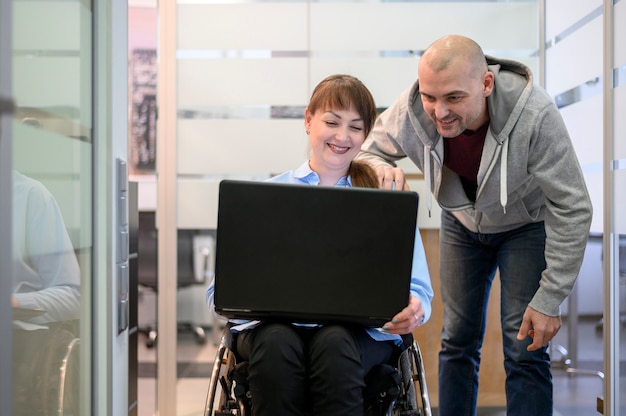 Photo gratuite jeune femme handicapée au bureau avec un collègue