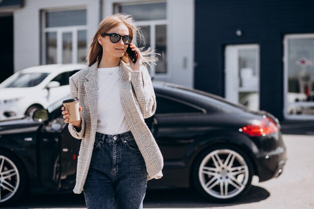 Jeune femme heureuse, boire du café en voiture