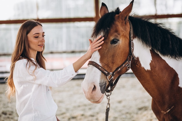 Jeune femme heureuse avec cheval au ranch