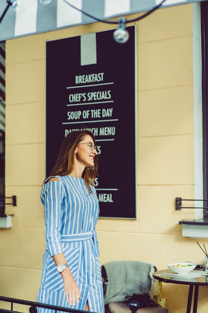 Photo gratuite jeune femme heureuse dans un café de rue souriant rire boire un café sur une terrasse