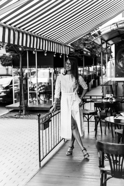 Photo gratuite jeune femme heureuse dans un café de rue souriant rire boire un café sur une terrasse