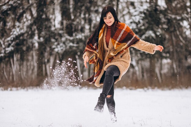 Jeune femme heureuse dans des vêtements chauds dans un parc d'hiver