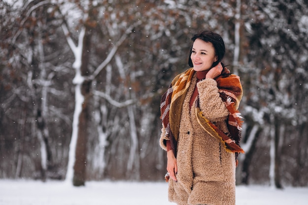 Jeune femme heureuse dans des vêtements chauds dans un parc d'hiver