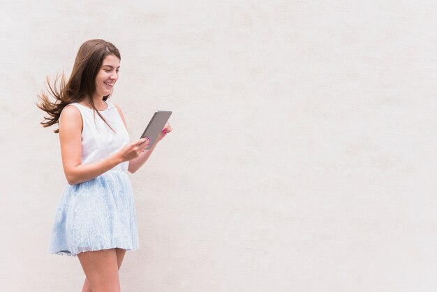 Jeune femme heureuse en regardant tablette