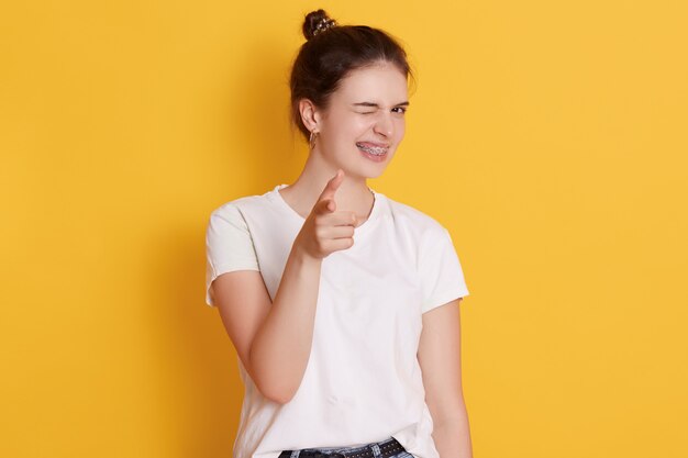 jeune femme, à, heureux, expression faciale, poser, isolé, sur, mur jaune