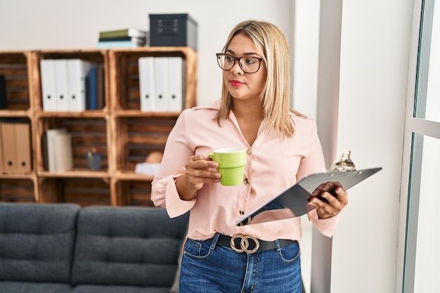 Photo gratuite jeune femme hispanique buvant du café ayant une session de psychologie centre de psychologie