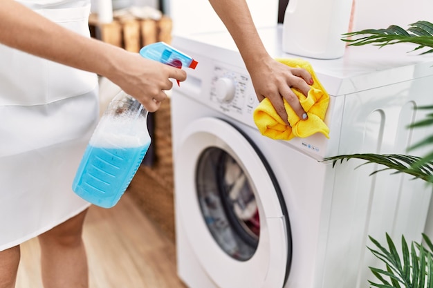 Photo gratuite jeune femme hispanique nettoyant la machine à laver à la buanderie