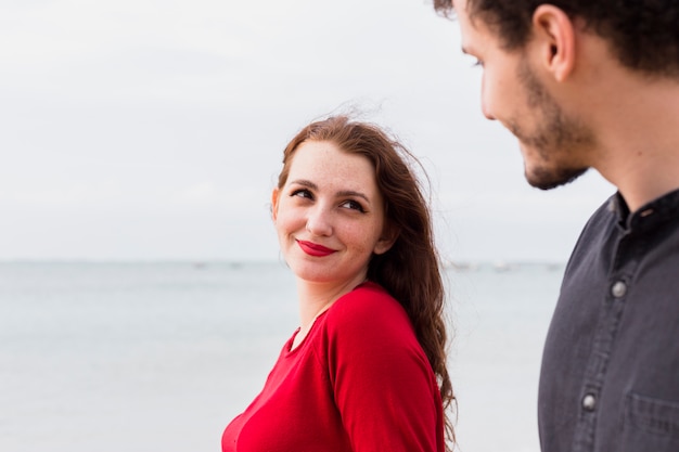 Jeune femme avec un homme au bord de la mer