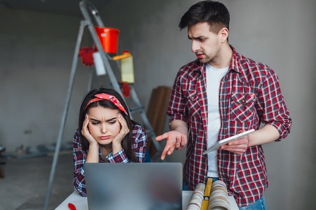 Jeune femme et homme se disputant pendant la rénovation de l'appartement