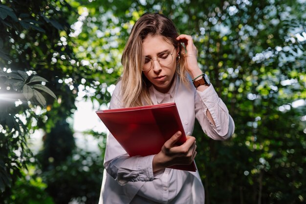 Jeune femme ingénieur agronome travaillant en serre.