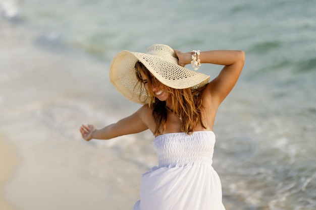 Jeune femme insouciante se sentant libre et s'amusant à la plage