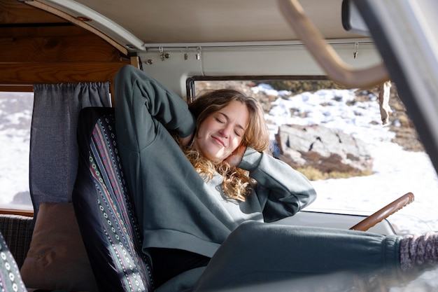 Jeune femme à l'intérieur d'un camping-car pendant le voyage d'hiver