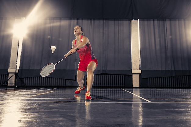 Jeune femme jouant au badminton au gymnase
