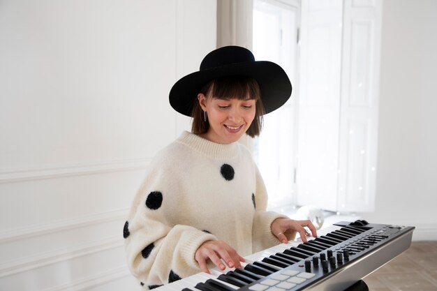 Jeune femme jouant du piano à l'intérieur