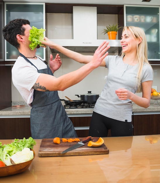 Jeune femme, jouer, laitue, légume, debout, derrière, table