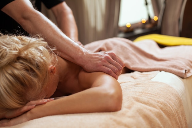 Jeune femme jouit d'un massage dans un spa