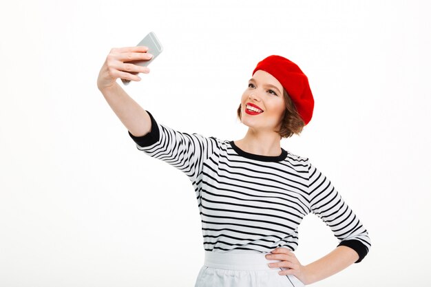 Jeune femme joyeuse faire selfie par téléphone mobile.