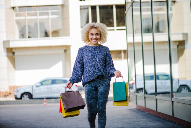 Jeune femme joyeuse marchant au magasin