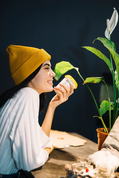 Photo gratuite jeune femme joyeuse avec une tasse de boisson à table