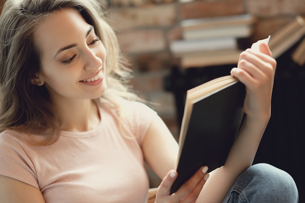 Jeune femme, lecture livre, chez soi