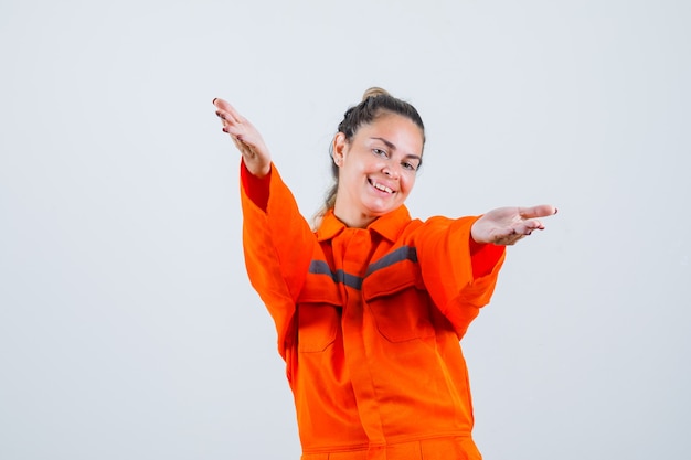 Photo gratuite jeune femme levant les bras pour étreindre quelqu'un en uniforme de travailleur et à la vue de face, bien-aimée.