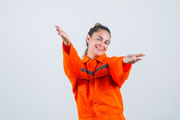 Jeune femme levant les bras pour étreindre quelqu'un en uniforme de travailleur et à la vue de face, bien-aimée.